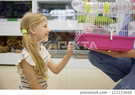 Cute daughter looking at new hamster cage in mother hands 121223688