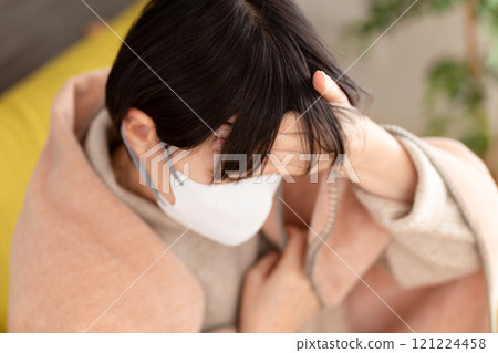 戴著面具的中高級婦女在冬季房間裡頭痛 戴著面具的中高級婦女在冬季房間裡頭痛 121224458