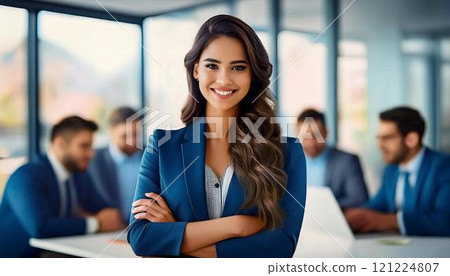 Smiling confident business leader looking at camera and standing in an office at team meeting. Portrait of confident businesswoman with colleagues in boardroom. 121224807