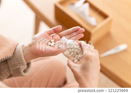 拿著一瓶藥丸的中高級婦女 拿著一瓶藥丸的中高級婦女 121225669