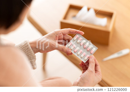 Middle-aged to senior women holding capsule medicine Middle-aged to senior women holding capsule medicine 121226000