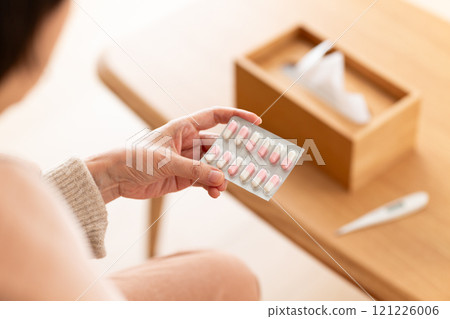 Middle-aged to senior women holding capsule medicine 121226006