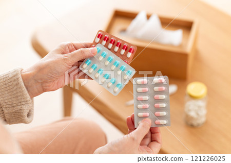 Middle-aged to senior women holding capsule medicine 121226025
