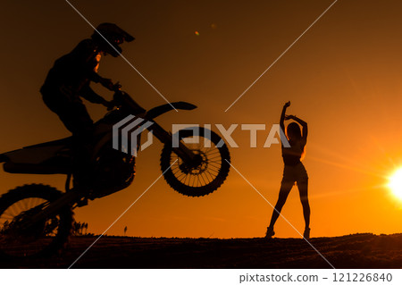 Silhouette of a man on a motorbike on the back whee Silhouette of a man on a motorbike on the back whee 121226840
