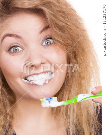 Woman brushing teeth having foam in mouth 121227176
