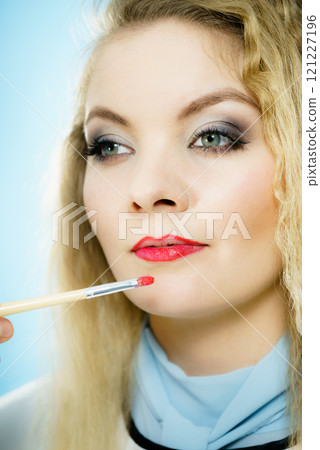 Applying lipstick on fashion model lips Applying lipstick on fashion model lips 121227196