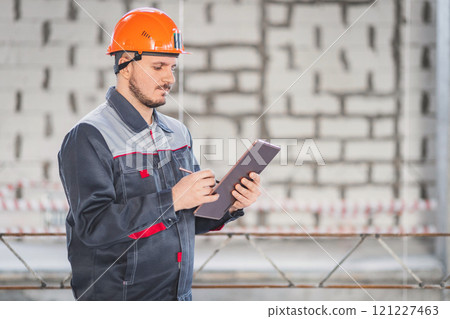 Caucasian construction worker with digital tablet and stylus in his hand, copy space. Caucasian construction worker with digital tablet and stylus in his hand, copy space. 121227463