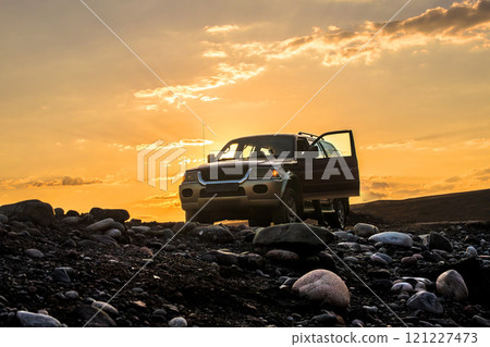 SUV off-road vehicle on foothill rocky off-road at dawn. Road trip, wilderness adventure, expedition or extreme 4x4 vehicle journey, copy space. SUV off-road vehicle on foothill rocky off-road at dawn. Road trip, wilderness adventure, expedition or extreme 4x4 vehicle journey, copy space. 121227473