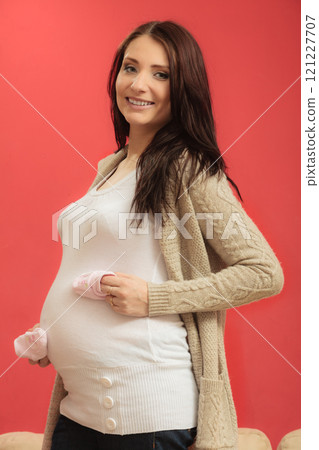 pregnant woman with small shoes for unborn baby 121227707