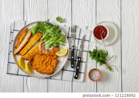 Pork Milanese with lettuce and lemon on a plate 121228092