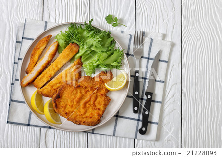 Pork Milanese with lettuce and lemon on a plate 121228093