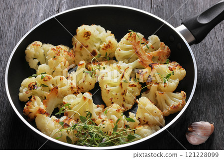 fried cauliflower florets on a skillet, top view fried cauliflower florets on a skillet, top view 121228099