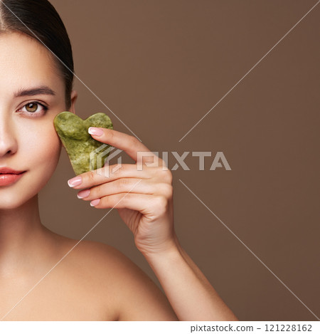 Young woman doing scrapping massage facial skin 121228162