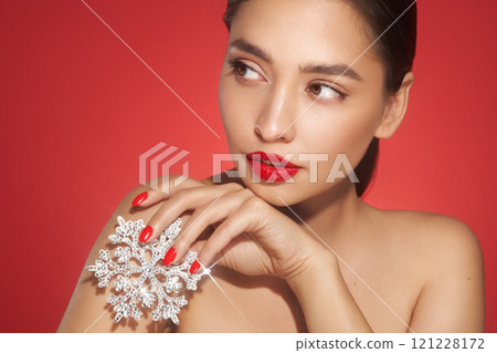 Beautiful young woman with glowing snowflake 121228172