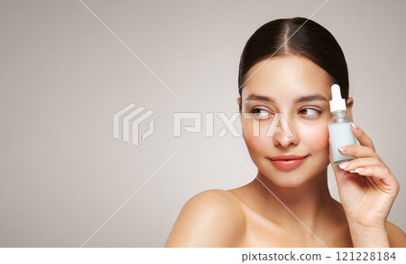 Woman holding a cosmetic jar of oil serum 121228184