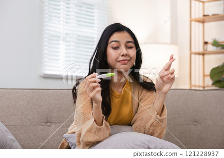 Exciting moment woman holds pregnancy test cozy living room emotional scene warm lighting hopeful outlook on future 121228937
