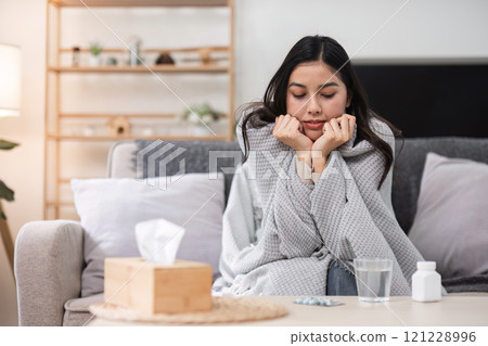 Feeling sick and unwell a young woman's struggle at home emotional lifestyle cozy indoor setting personal reflection 121228996