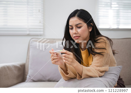 Woman contemplating pregnancy test results at home intimate moment in womb of life reflective atmosphere 121228997