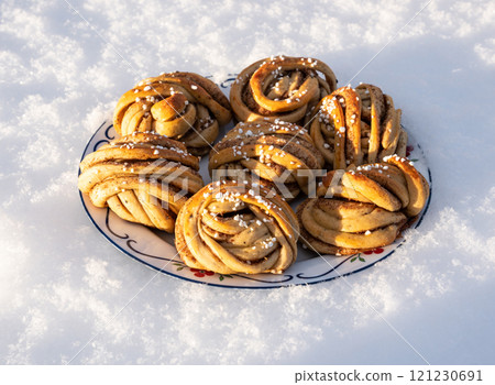 Plate of homemade gourmet cinnamon rolls on a plate in the snow 121230691