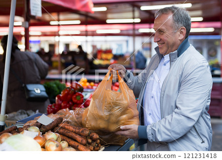 Middle aged man buying potatoes Middle aged man buying potatoes 121231418