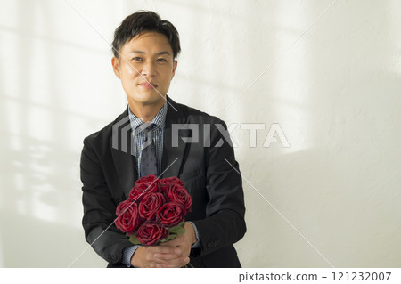 一個男人微笑著拿著一束鮮花 一個男人微笑著拿著一束鮮花 121232007