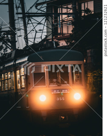 傍晚時分,江之島電鐵305型列車駛過鎌倉市越江的小巷。 傍晚時分,江之島電鐵305型列車駛過鎌倉市越江的小巷。 121232621