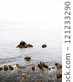 A serene seascape featuring scattered rocky formations emerging from calm ocean waters 121233290