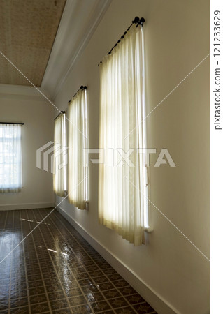 The large windows and chiffon curtains in a Western-style house create a beautiful soft interior lighting. The large windows and chiffon curtains in a Western-style house create a beautiful soft interior lighting. 121233629