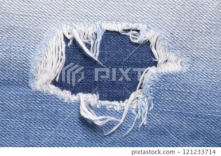 Closeup detail of torn on blue jeans. Denim jeans texture. 121233714