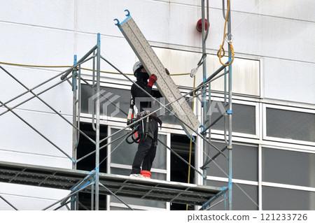 Construction site: Factory exterior wall renovation work: Temporary scaffolding assembly work Construction site: Factory exterior wall renovation work: Temporary scaffolding assembly work 121233726
