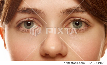Close-up image of female face, big eyes, nose. Beautiful young woman with nude makeup and perfect skin. 121233965