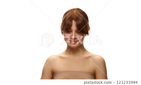 Portrait of young tender woman with bare shoulders, in beige top, posing against white studio background. Flawless skin and no makeup 121233994