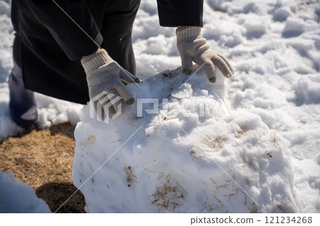 A woman making a snowman A woman making a snowman 121234268