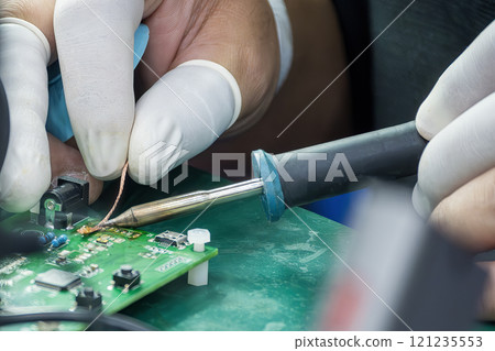 Close up scene the soldering operation by skill operator with rubber finger cot. 121235553