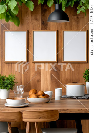 A wooden table with three frames hanging on the wall above it 121236182