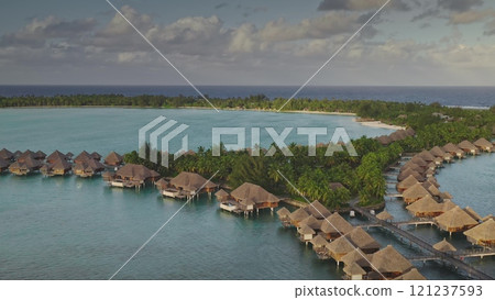 Breathtaking aerial view of tropical luxury resort with stunning overwater bungalows huts nestled along the shore of crystal clear lagoon. Visit Bora Bora, remote wild nature, exotic summer travel Breathtaking aerial view of tropical luxury resort with stunning overwater bungalows huts nestled along the shore of crystal clear lagoon. Visit Bora Bora, remote wild nature, exotic summer travel 121237593