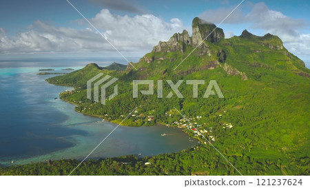 Breathtaking aerial view of Bora Bora island lagoon showing its lush green vegetation, turquoise coral reef, and majestic mount Otemanu. Aerial drone shot. French Polynesia travel tropical paradise 121237624