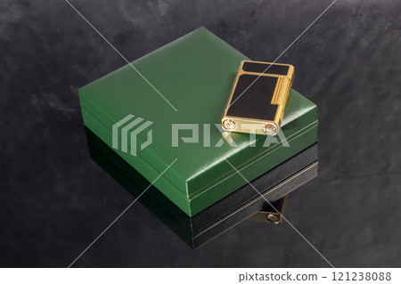 High quality lighter in a box on a dark background. Office interior. High quality lighter in a box on a dark background. Office interior. 121238088