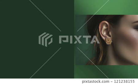 Close-up of a woman on an emerald background with an accent on an earring with a gemstone. 121238155