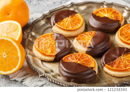 Homemade shortbread cookies with candied orange and chocolate glaze close-up in a plate. Horizontal 121238393