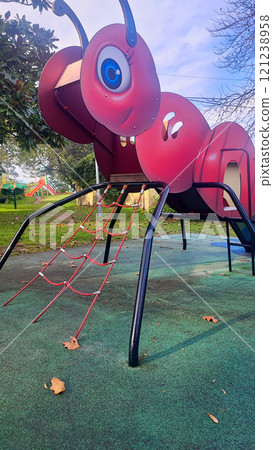 The children's playground is colorful on a green yard. Children's slide on the playground in the form of an ant. Concept of unusual architectural solutions The children's playground is colorful on a green yard. Children's slide on the playground in the form of an ant. Concept of unusual architectural solutions 121238958