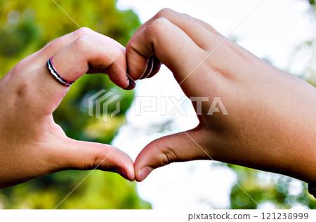 Close-up of heart-shaped hands against the sky Close-up of heart-shaped hands against the sky 121238999