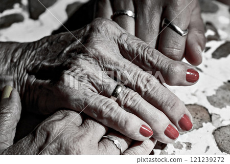 Affection and tenderness of a granddaughter towards her grandmother. Signs of aging in the hands. Black and white effect Affection and tenderness of a granddaughter towards her grandmother. Signs of aging in the hands. Black and white effect 121239272