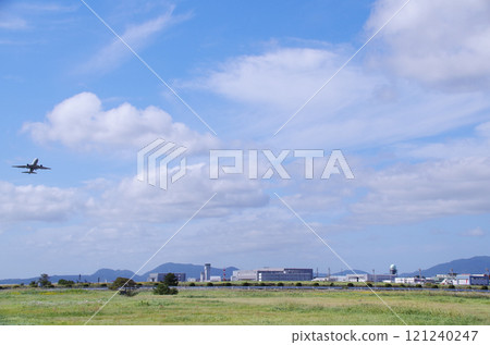 A distant view of the airport with buildings lined up across the grassland 121240247