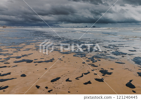 Oil in sea coastline after a tanker wreck. Oil fuel polluted sandy beach 121240445