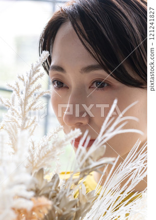 Middle-aged woman holding a bouquet indoors 121241827