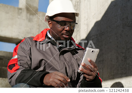 African american workman speaks on smartphone by video link African american workman speaks on smartphone by video link 121242438