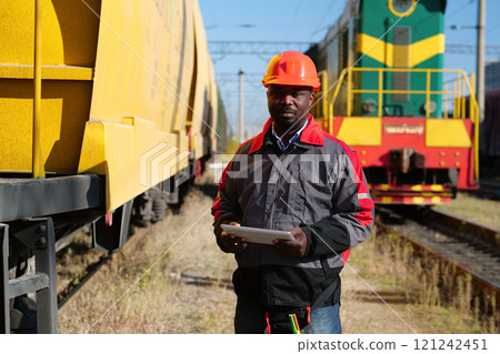 Railroad man in uniform and red hard hat with computer Railroad man in uniform and red hard hat with computer 121242451