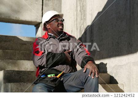African american worker at project site has a stomachache, he touches his stomach 121242452