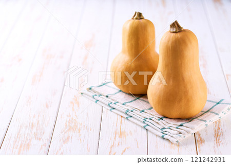 butternut pumpkin on a white table, selective focus. butternut pumpkin on a white table, selective focus. 121242931